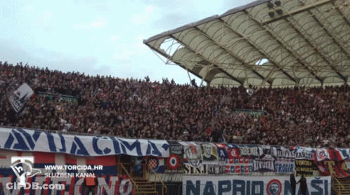 A Stadium Full Of People With A Banner That Says Avjacma GIF