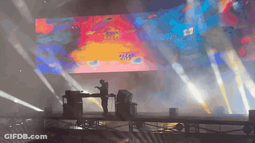 A Stage With A Large Screen Behind It That Says Dread City GIF