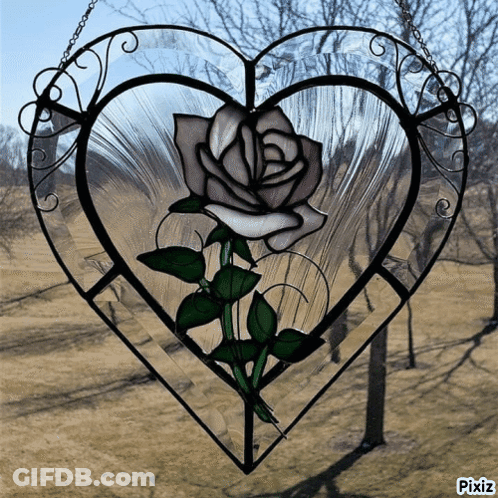 A Stained Glass Heart With A White Rose In The Center GIF