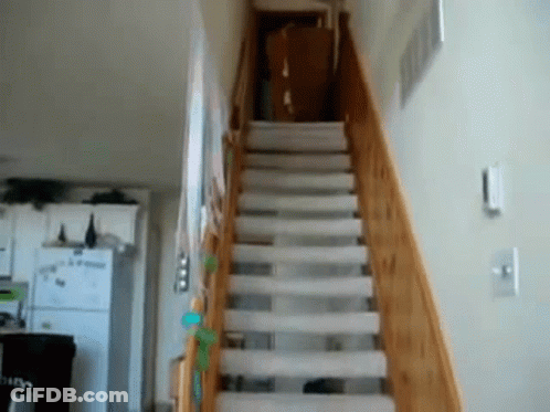 A Staircase With A White Carpet And A Wooden Railing In A House GIF
