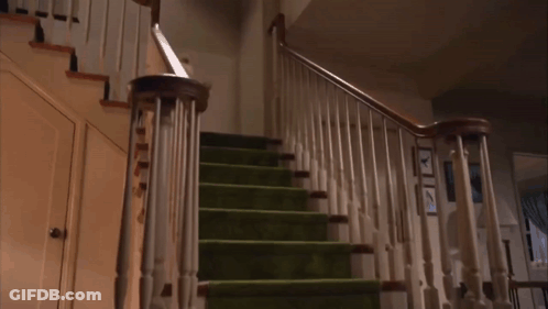 A Staircase With Green Carpeted Steps And A White Railing GIF
