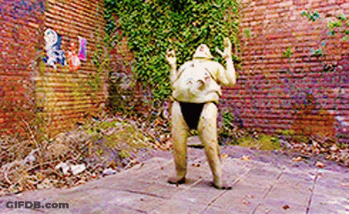 A Statue In Front Of A Brick Wall That Says ' A ' On It GIF