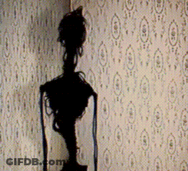 A Statue Is Silhouetted Against A Wall With A Pattern Of Circles GIF
