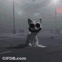 A Statue Of A Cat With Big Eyes Is Sitting On A Box In A Parking Lot . GIF