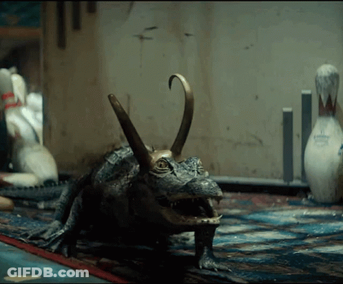 A Statue Of A Crocodile With A Bowling Pin In The Background .. GIF
