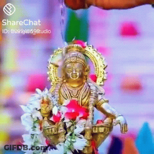 A Statue Of A Deity Is Surrounded By Flowers And Water Being Poured On It . GIF