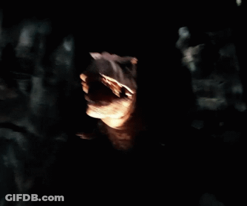 A Statue Of A Dinosaur With Its Mouth Wide Open GIF