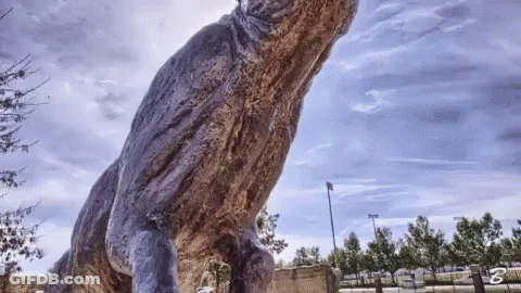 A Statue Of A Dinosaur With The Letter B On The Bottom Left GIF