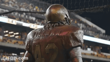 A Statue Of A Football Player Wearing The Number 12 GIF