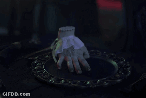 A Statue Of A Hand Is Sitting On A Plate GIF