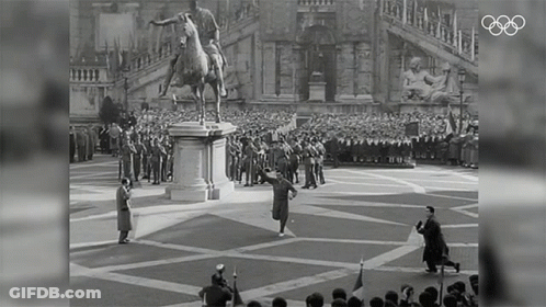 A Statue Of A Man Riding A Horse Is In Front Of A Crowd Of People GIF