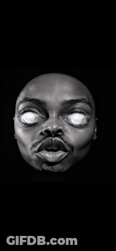 A Statue Of A Man 'S Face With Glowing Eyes In The Dark GIF