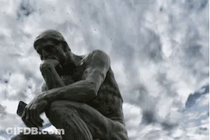A Statue Of A Man Sitting Down Thinking With A Phone In His Hand . GIF