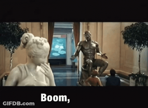 A Statue Of A Man Sitting On A Throne Next To A Woman And The Words Boom GIF