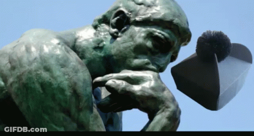 A Statue Of A Man Thinking With His Hand On His Chin And A Hat In The Background GIF