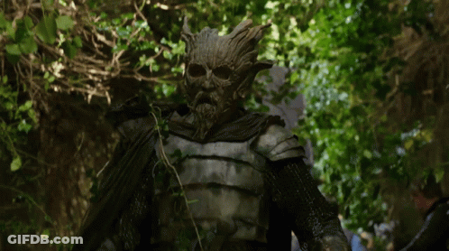 A Statue Of A Man With A Beard And A Tree Face GIF