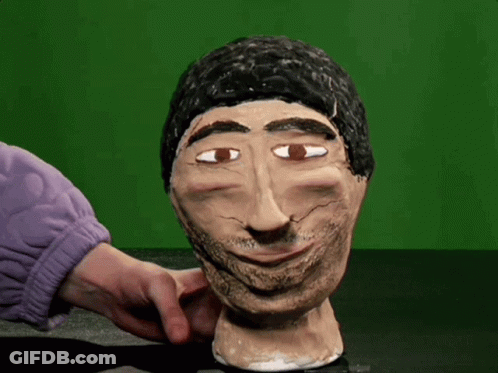 A Statue Of A Man With A Beard Is Being Touched By Someone In A Purple Sweater GIF