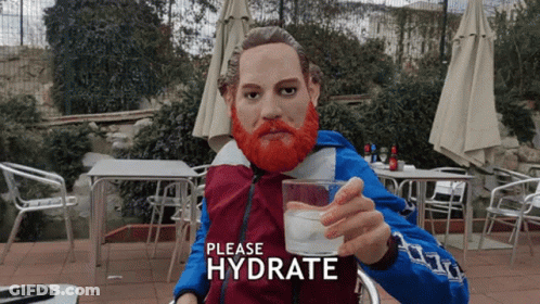 A Statue Of A Man With A Red Beard Is Holding A Glass Of Water With The Words Please Hydrate Above Him GIF
