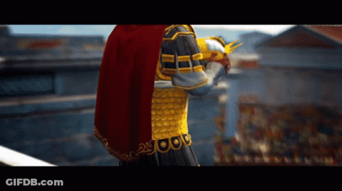 A Statue Of A Man With A Red Cape And Gold Armor With The Number 2 On It GIF