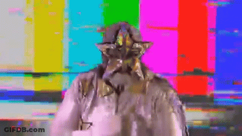 A Statue Of A Man With A Star On His Head Is Standing In Front Of A Colorful Background . GIF