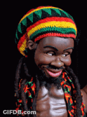 A Statue Of A Man With Dreadlocks And A Colorful Hat GIF