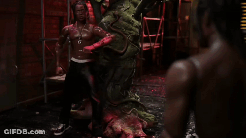 A Statue Of A Man With Dreadlocks And A Necklace That Says ' G ' On It GIF