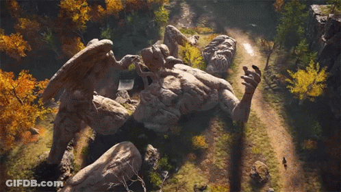 A Statue Of A Man With Wings Is Laying On Top Of A Rock . GIF