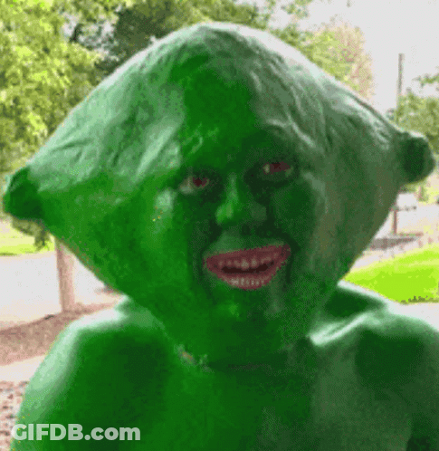 A Statue Of A Person With A Green Head And Red Eyes GIF