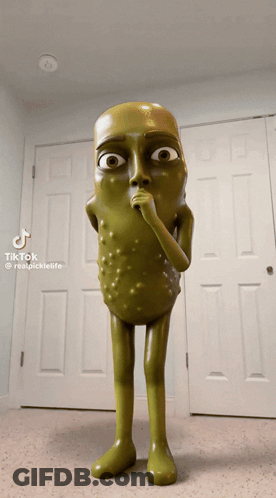 A Statue Of A Pickle With A Surprised Look On His Face Is Standing In Front Of A Door GIF