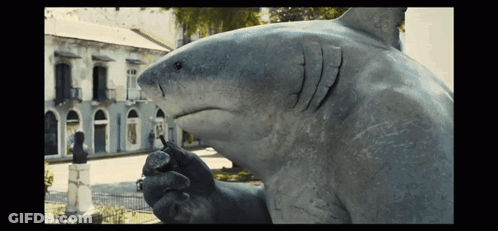 A Statue Of A Shark In Front Of A Building That Says ' A ' On It GIF