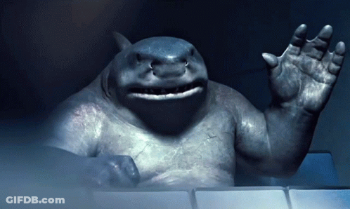 A Statue Of A Shark Is Waving His Hand In The Dark GIF