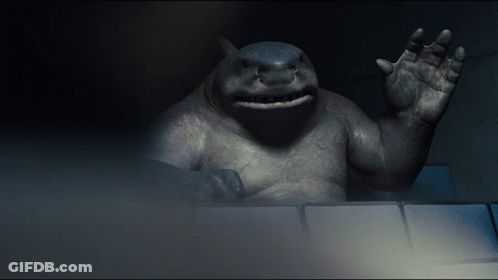 A Statue Of A Shark Waving Its Hand In The Dark GIF