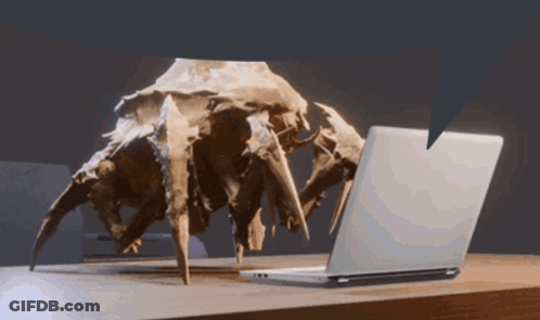 A Statue Of A Spider Looking At A Laptop GIF