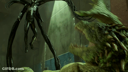 A Statue Of A Spider Man Standing Next To A Large Green Monster GIF