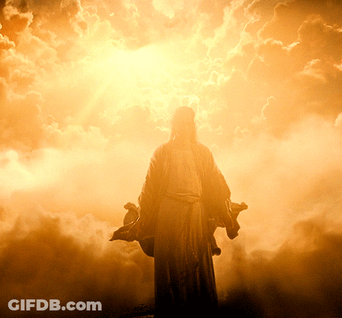 A Statue Of Jesus In A Cloudy Sky With The Sun Behind Him GIF