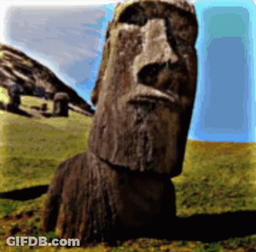 A Statue With A Face Carved Into It Is Sitting In A Grassy Field GIF