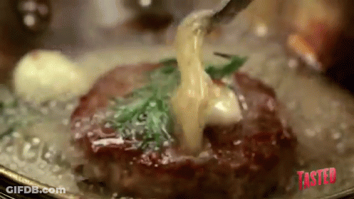 A Steak Is Being Cooked In A Pan With A Fork And Sauce Being Poured Over It . GIF