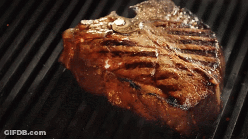 A Steak Is Cooking On A Grill With A Lot Of Smoke Coming Out Of It GIF