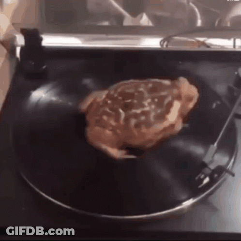A Steak Is Sitting On A Record On A Record Player GIF