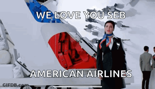 A Stewardess Is Standing In Front Of An American Airlines Logo GIF