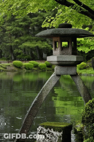 A Stone Lantern Sits In The Middle Of A Pond With Trees In The Background GIF