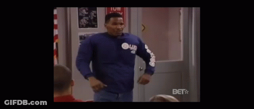 A Stop Sign Is In The Middle Of A Classroom With People Sitting At Desks . GIF