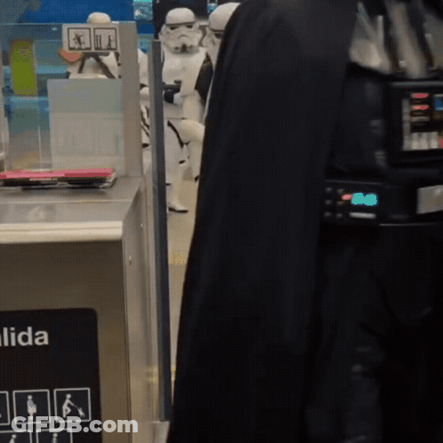 A Storm Trooper Is Standing In Front Of A Sign That Says Entrada GIF