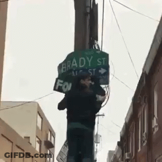 A Street Sign For Brady St. Is Hanging From A Pole GIF