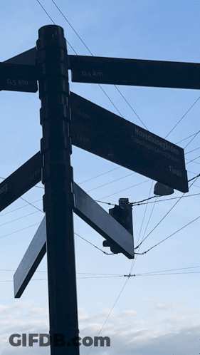 A Street Sign Shows The Distance To Various Locations Including Tivoli GIF