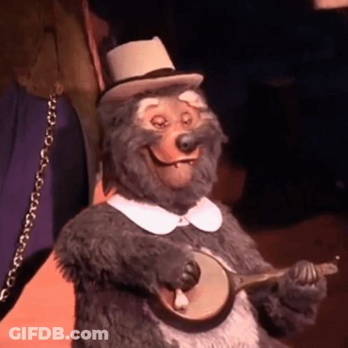 A Stuffed Animal Bear Is Playing A Banjo And Smiling GIF