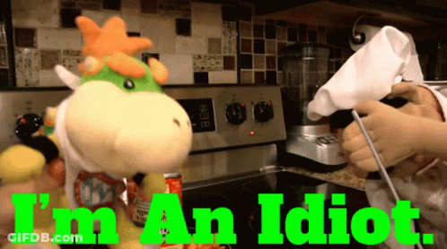 A Stuffed Animal In A Kitchen With The Words " I 'M An Idiot " Above It GIF
