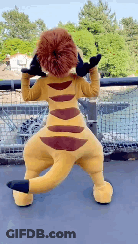A Stuffed Animal In A Lion Costume Is Standing In Front Of A Net GIF