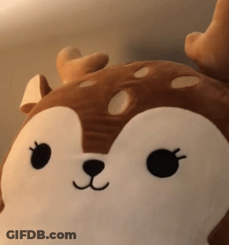 A Stuffed Animal In The Shape Of A Deer With A Black Nose And Eyes GIF
