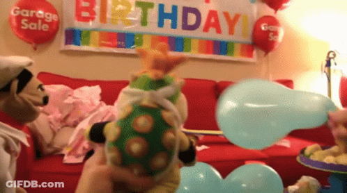 A Stuffed Animal Is Blowing Up A Blue Balloon In Front Of A Birthday Banner GIF